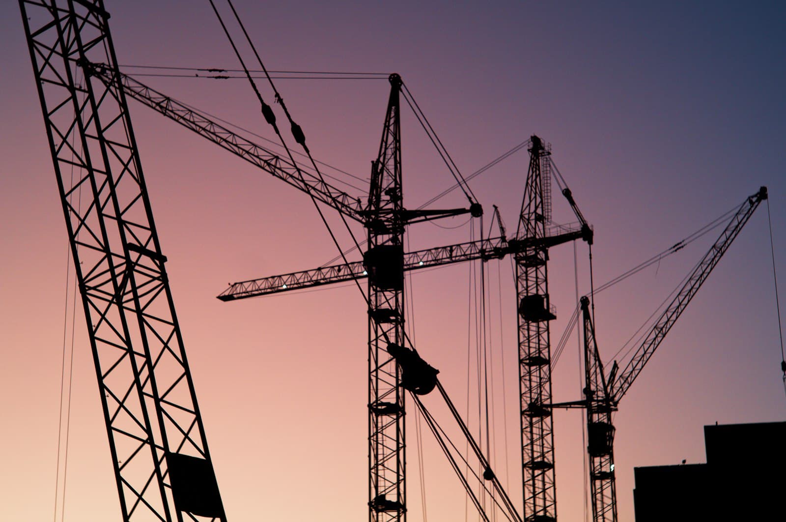 Construction cranes on a city skyline